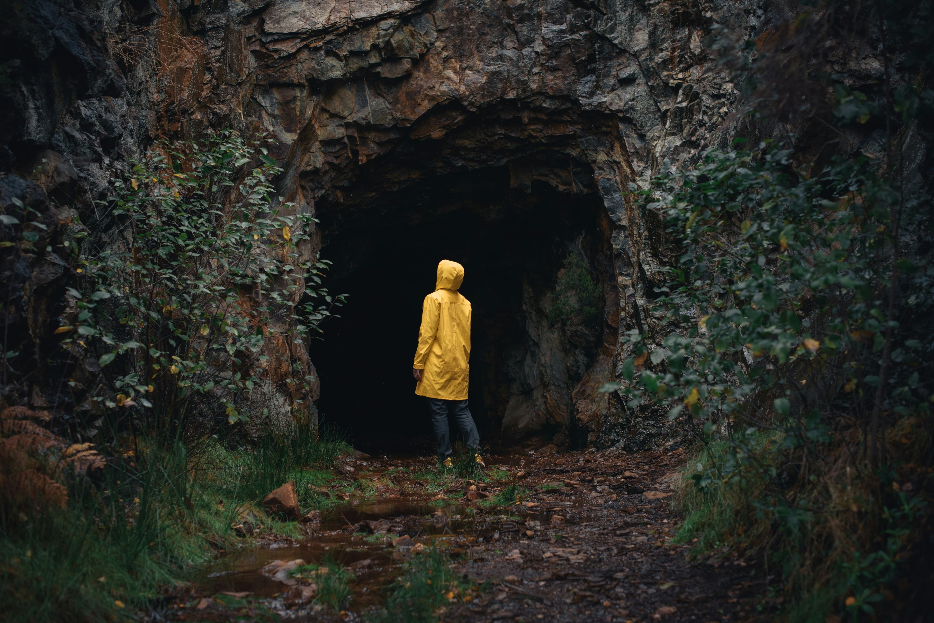 Child looking up at cave entrance